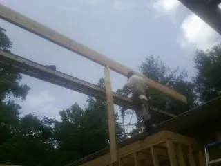 Carpenter setting a ridge beam over a new addition frame — Ice Dam Removal by Roofing Brothers in Scotland Neck