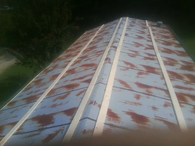 Rusted metal roof panels with new wood purlins before replacement — Storm Damage Roof Repair in Scotland Neck by Roofing Brothers
