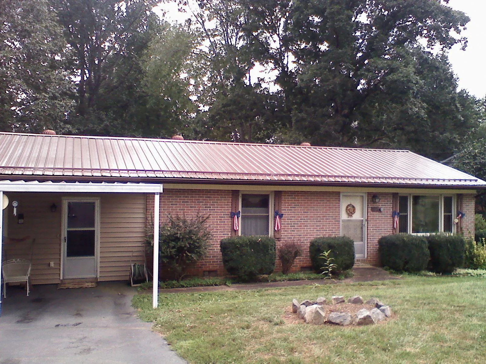 Bronze metal roof and carport on a brick ranch home — Roof Repair work by our crew in Scotland Neck